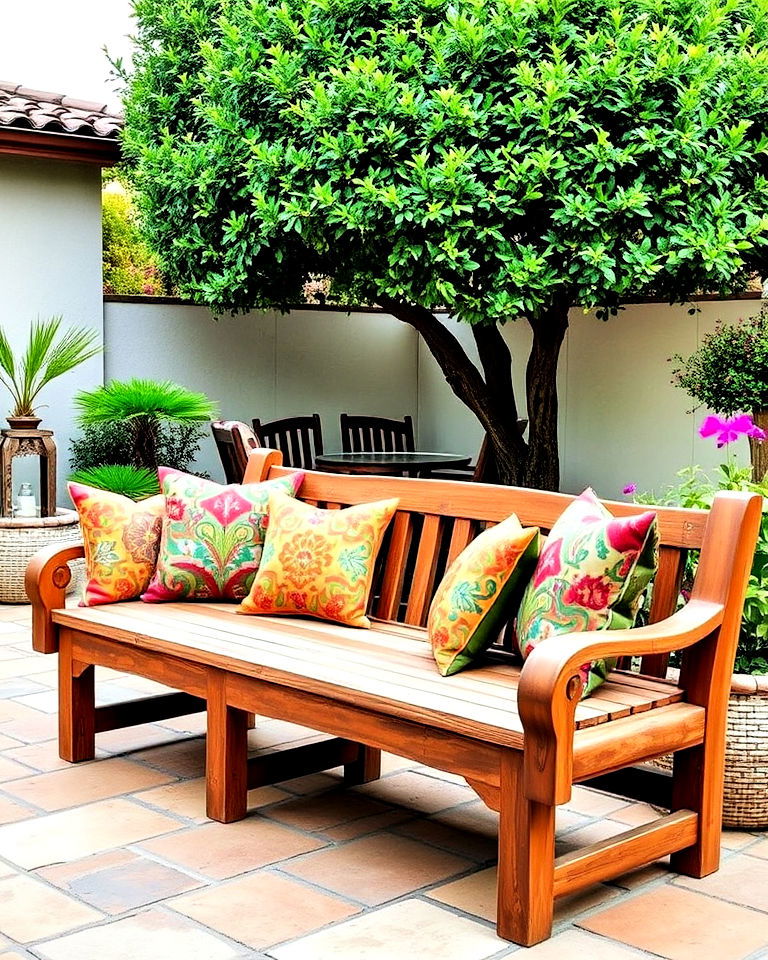 wooden patio bench with colorful pillows